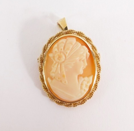 A shell cameo pendant brooch, with raised relief cameo depicting maiden, in rope twist border, with pendant loop and single pin back, marked 375, 4.3g all in, the cameo 3cm x 2cm.