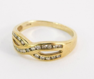 A dress ring, formed with two links crossed over, set with tiny diamonds, in a yellow metal setting, stamped 10kt, size O½, 2.5g all in, boxed.