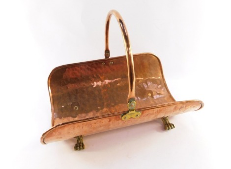 A copper flower basket, with swing handle, raised on four brass lion's paw feet, 40cm high, 45cm wide, 30cm deep.