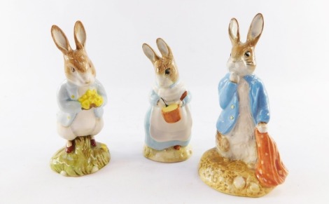 Three Beswick Beatrix Potter figures, comprising Peter with daffodil, 11cm high, Mrs Rabbit cooking, 10cm high, Peter and the red handkerchief, 12cm high.