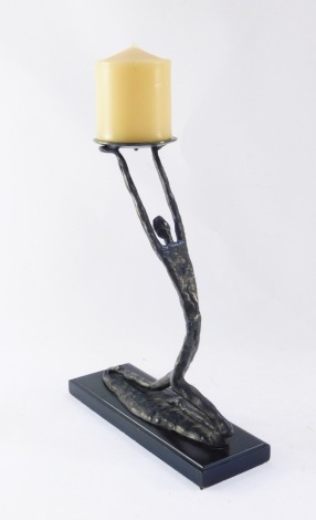 Manner of Hagenauer. A modern art bronze candle stand, modelled as a kneeling figure holding aloft a candle dish, on an ebonised base, 30cm high.