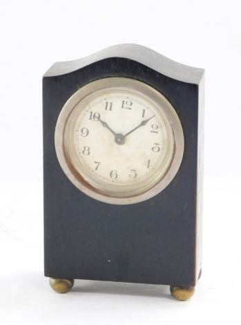 An Art Deco desk clock, the ebony frame with a steel set dial on white finish, with bun feet, 12cm high, 7.5cm wide, 4cm deep.