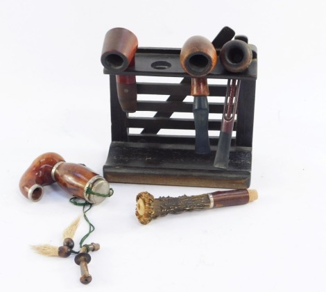 A wooden gate form pipe rack, and four briar wood pipes, 17cm high, 16cm wide, the pipes with Royal emblem, including Falcon, Royal Dutch, Big Ben Lockie, and a horn handled Brilinge.