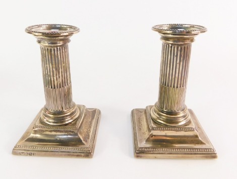 A pair of Victorian loaded silver candlesticks, of fluted column form, raised on a stepped base, , Sheffield 1890, 13cm high.