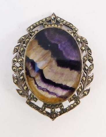 A Blue John and marcasite bar brooch, the oval central set Blue John in rub over setting with outer marcasite border, silver plated, 5cm wide.