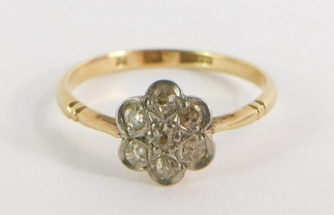 A 18ct gold and platinum daisy dress ring, the daisy set with tiny diamonds in a platinum setting in V splayed and ribbed shoulders, size N½, 1.8g all in.