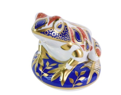 A Royal Crown Derby frog paperweight, seated on blue ground, silvered stopper, 9cm high, boxed.