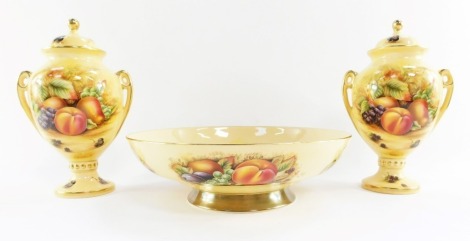 A group of Aynsley Orchard Gold porcelain, comprising a fruit bowl, 26cm wide, and a pair of twin handled vases and covers, 23cm high. (3)