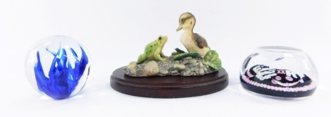A group of collectables, comprising a Border Fine Arts duckling and frog figure group, on wooden base, 10cm high, a Wedgwood blue glass paperweight and a Queen Elizabeth 1977 commemorative faceted glass paperweight. (3)
