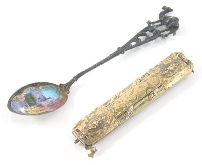 An early 20thC silver gilt buckle or hair clip, of oblong form articulating with a hinged centre with a repousse and chased floral decoration partially marked, possibly French, when closed 7cm wide and an enamel teaspoon. (2) - 2