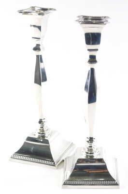 A pair of Elizabeth II silver candlesticks, each with inverted square dish holders on turned stems and square bases with a beaded outline, London 1966, 29cm high, 18½oz. (2) - 2