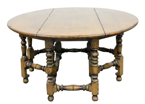 A Jacobean style solid oak and elm wake dining table, with double turned gate leg action, united by turned stretchers, 77cm high, 65cm wide, 160cm extended, 203cm deep.