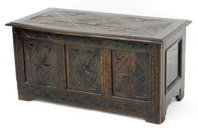 A 17thC style oak coffer, with a foliate carved hinged lid, vacant interior, the triple panelled front carved with floral medallions, raised on bracket feet, 45cm high, 91cm wide, 46cm deep (AF)