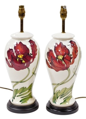 A pair of Moorcroft pottery Dancing Flame table lamps, of baluster form, against a cream ground, on turned hardwood bases, 47cm high overall.