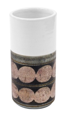 A Troika pottery cylindrical vase, decorated with two bands of circles, against a white ground, painted marks, 19cm high. (AF)