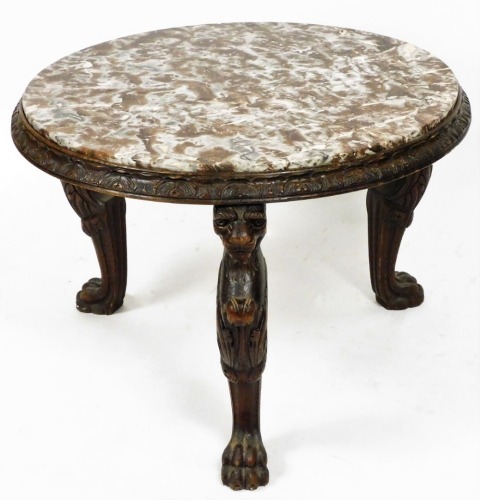 A late 19thC Continental marble topped occasional table, the circular top raised on heavily carved lions head and hairy paw legs, 63cm high, 84cm diameter.
