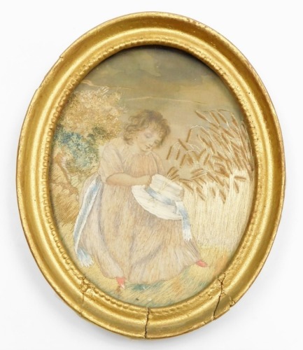 A 19thC silk embroidery of a girl with bonnet in wheat field, 13cm x 17cm, in an oval gilt frame. (AF)