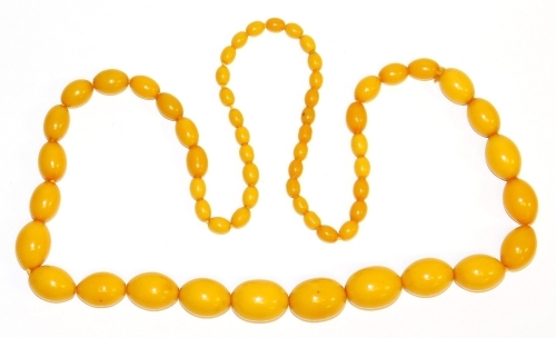 An imitation butterscotch amber beaded necklace, with light amber beads, of graduated form, on string strand, the largest 2.5cm wide, the smallest 1cm wide.