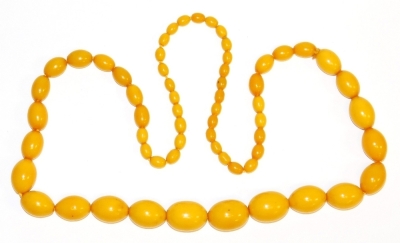 An imitation butterscotch amber beaded necklace, with light amber beads, of graduated form, on string strand, the largest 2.5cm wide, the smallest 1cm wide.