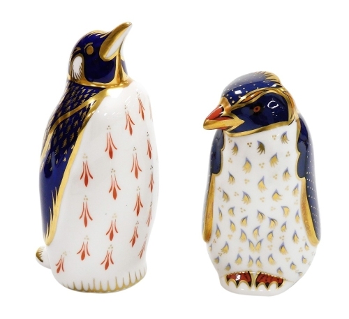 A Royal Crown Derby penguin porcelain paperweight, limited edition number 457/500, with silver stopper, 13cm high, boxed, and a Rock Hopper penguin, designed by John Ablitt, with gold stopper and red printed marks to underside, 10cm high, boxed.