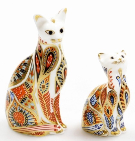 A Royal Crown Derby Siamese cat porcelain paperweight, with gold stopper and red printed marks to underside, 14cm high, and a Siamese kitten porcelain paperweight, with gold stopper, 9cm high. (kitten boxed)