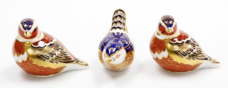 Three Royal Crown Derby bird porcelain paperweights, compromising two chaffinches, with gold stopper and red printed marks to underside, 9cm wide, and a wren, with gold stopper, 9cm wide, all boxed.