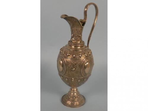 A Victorian silver claret jug embossed and engraved with panels of foliate scrolls