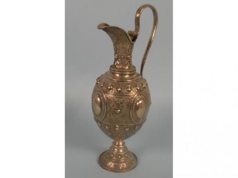 A Victorian silver claret jug embossed and engraved with panels of foliate scrolls
