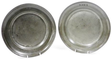 Two similar pewter plates, each with indistinct touch marks to the reverse, and stamped with initials to the front, 22.5cm diameter.