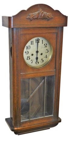 An early 20thC oak cased wall clock, with silvered dial bearing Arabic numerals, eight day movement with coil strike, the case with glazed front, no key, 77cm high.