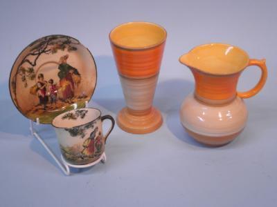 A Shelley jug decorated with bands of orange and brown