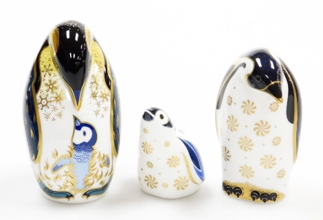 Three Royal Crown Derby penguin porcelain paperweights, penguin and chick, with gold stopper, 13cm high, Aurora, Exclusive for the Collectors Guild, with gold stopper and grey printed marks to underside, 11cm high, and Snowflake, for the Royal Crown Derby