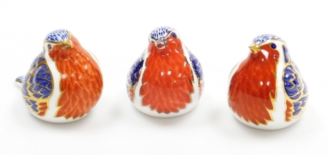 Three Royal Crown Derby robin porcelain paperweights, all with gold stoppers, 9cm wide, boxed.