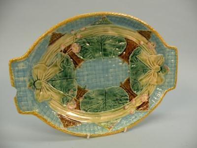 A Victorian Majolica dish with moulded decoration of ribbons and leaves