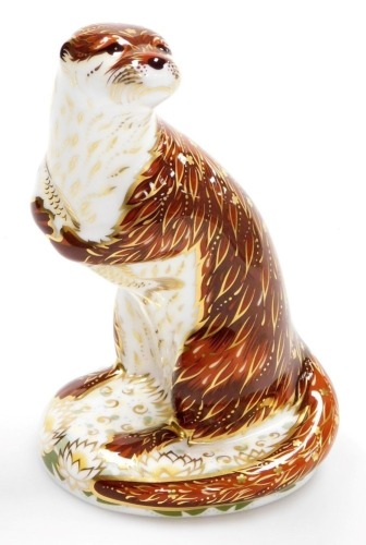 A Royal Crown Derby Playful Otter porcelain paperweight, with gold stopper and red printed marks to underside, 15cm high, boxed.