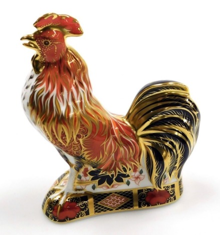 A Royal Crown Derby The Fighting Cockerel porcelain paperweight, an Exclusive to Sinclairs, with gold stopper and gold printed marks to underside, 18cm high, boxed.