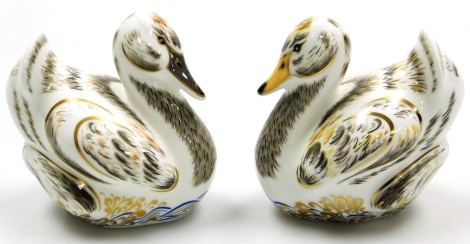 Two Royal Crown Derby Royal Cygnet porcelain paperweights, Royal Cygnet George and Royal Cygnet Charlotte, limited edition numbers 243/750, with gold stoppers and grey printed marks to underside, 10cm high, boxed.