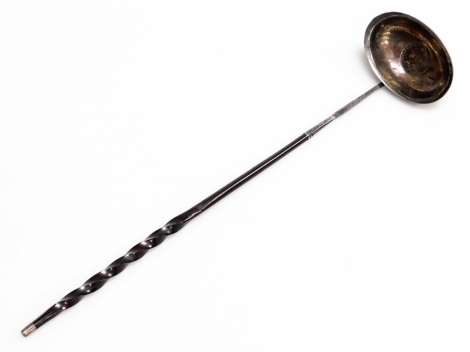 A Georgian toddy ladle, the bowl inset with a George II coin, with a whale bone twisted stem handle, 36.5cm long.