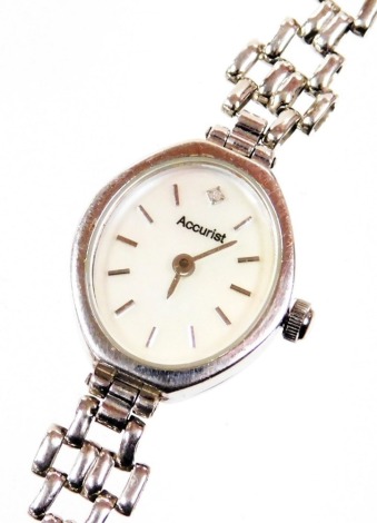 An Accurist 9ct white gold ladies wristwatch, with oval silvered colour dial set with tiny diamond, on a fancy gate style bracelet, 18cm long, 10.4g all in, boxed.