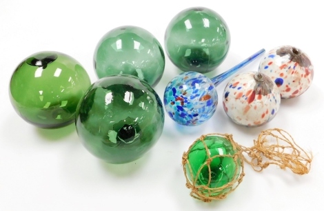 A collection of coloured glassware, to include various green glass orbs, 13cm wide, two mottled glass orbs, on a white ground decorated with flecks of blue and red, 9cm diameter, etc. (a quantity)