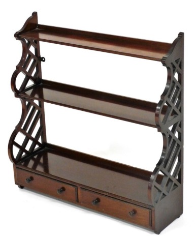 A 20thC mahogany hanging display rack, with two shelves, the sides with pierced decoration and two drawers with turned wooden handles, 63cm high, 61cm wide, 19cm deep.