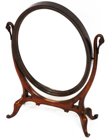 A Victorian style mahogany framed table mirror, the oval glass flanked by swan headed supports, on quadruple scroll feet, 82cm high, 59cm wide, 24cm deep.