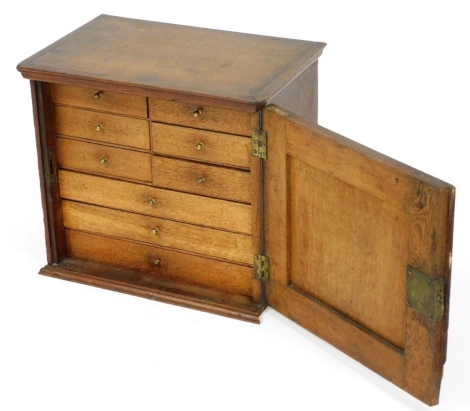 A late 19thC oak tabletop collector's chest, the panelled door enclosing an arrangement of drawers, on a plinth base, 37cm high, 41cm wide, 26.5cm deep. (AF)