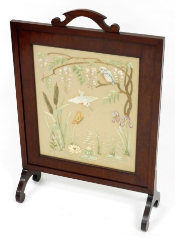 A Victorian mahogany rectangular framed fire screen, with a shaped handle, centre inset with an embroidered panel depicting a river scene with kingfishers, raised on scroll feet, 87cm high, 58cm wide.