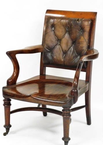 A 19thC mahogany smoker's chair, with a brown leather button back, solid seat, raised on turned legs, brass capped on castors.