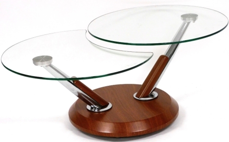 A modern two sectional rotating glass top coffee table, on a circular hardwood base, the top 70cm diameter.