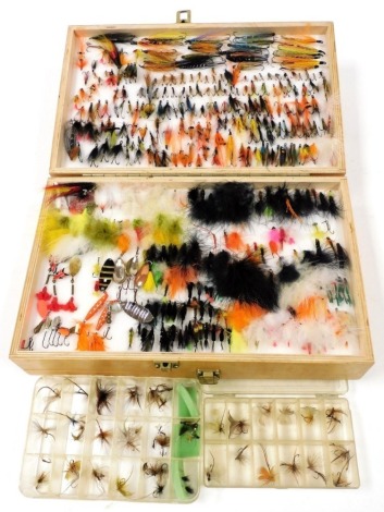 A collection of fishing flies contained in a wooden reservoir fly box, including salmon flies and tube flies, reservoir lures, mayflies, dry flies, wet flies, etc., a small collection of spinners, and two additional fly boxes with contents.