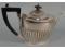 A silver part fluted tea pot with an ebonised knob and handle
