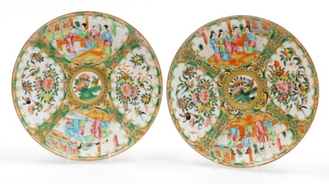 A pair of 19thC Chinese Canton porcelain plates, decorated in enamels with figures and flowers in shaped panels, 25cm diameter.