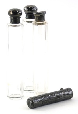 A late Victorian silver perfume bottle, of cylindrical form with hinged lid and stopper, 10cm high, and three cut glass and silver needle jars, 2oz (4).